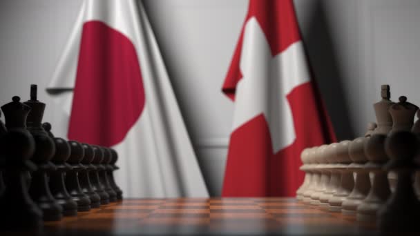 Шахматная игра против флагов Японии и Швейцарии. Политическая конкуренция — стоковое видео