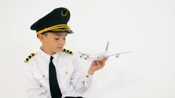 Niño vistiendo uniforme pilotos sostiene moder avión de escala — Vídeo de stock