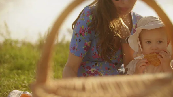 Liten baby flicka och hennes mamma med picknick på en sommardag — Stockfoto