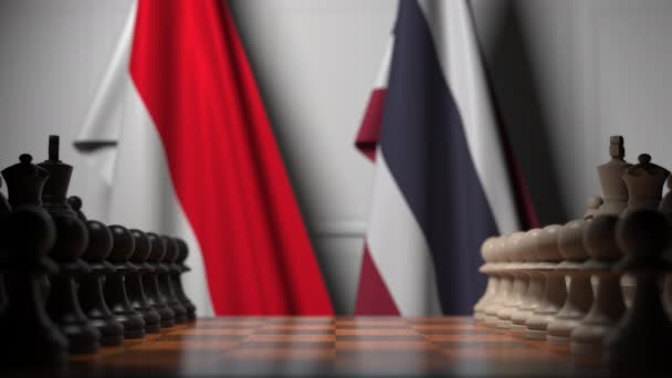 棋盘上的棋子后面是印度尼西亚和泰国的旗帜。国际象棋游戏或政治竞争相关3D动画 — 图库视频影像