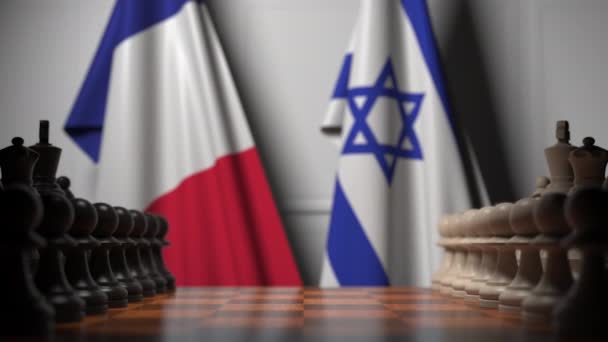Флаги Франции и Израиля за пешками на шахматной доске. Шахматная игра или политическое соперничество — стоковое видео