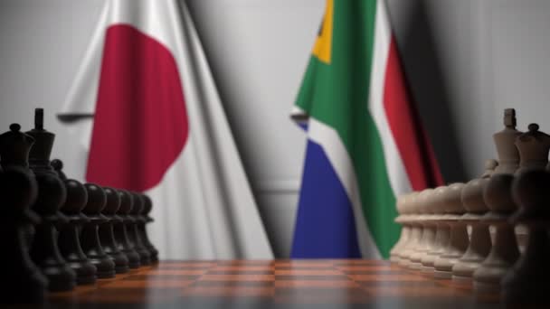 Banderas de Japón y Sudáfrica detrás de peones en el tablero de ajedrez. Juego de ajedrez o rivalidad política relacionada con la animación 3D — Vídeo de stock