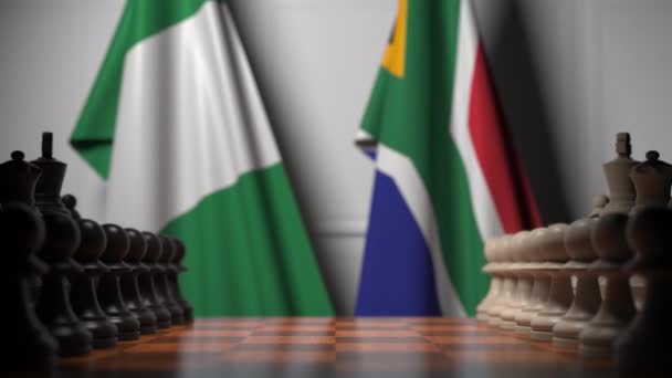 Bandiere della Nigeria e del Sudafrica dietro pedoni sulla scacchiera. Gioco di scacchi o rivalità politica relativi animazione 3D — Video Stock