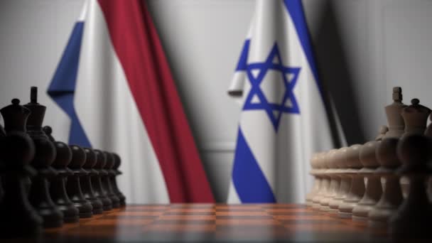Флаги Нидерландов и Израиля за пешками на шахматной доске. Шахматная игра или политическое соперничество — стоковое видео