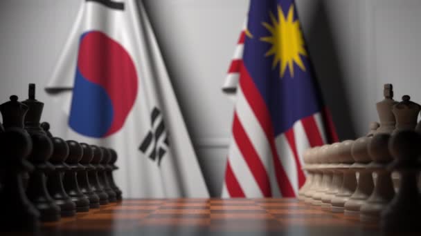 Flaggen Südkoreas und Malaysias hinter Bauern auf dem Schachbrett. Schachspiel oder politische Rivalität im Zusammenhang mit 3D-Animation — Stockvideo