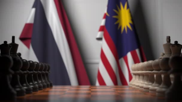 Flaggor i Thailand och Malaysia bakom brickor på schackbrädet. Schack spel eller politisk rivalitet relaterade 3D-animering — Stockvideo