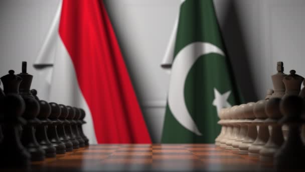 Флаги Индонезии и Пакистана за пешками на шахматной доске. Шахматная игра или политическое соперничество — стоковое видео