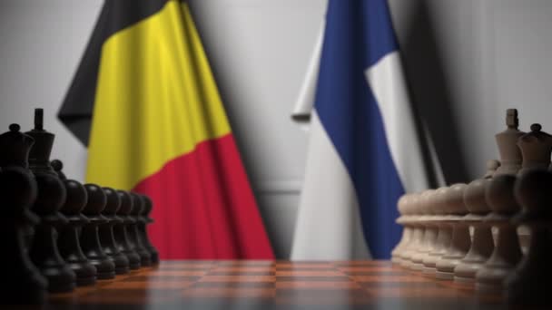Флаги Бельгии и Финляндии за пешками на шахматной доске. Шахматная игра или политическое соперничество — стоковое видео