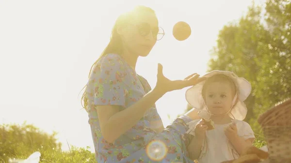 Jonge vrouw en haar kleine baby meisje picknicken op een mooie zomerdag — Stockfoto