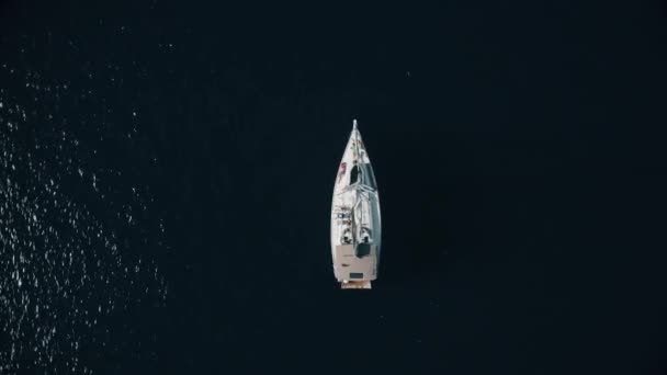 Aerial top down view of unknown people relaxing on a sailing yacht at sea — Stock Video