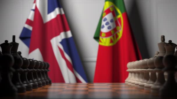 Флаги Великобритании и Португалии за пешками на шахматной доске. Шахматная игра или политическое соперничество — стоковое видео