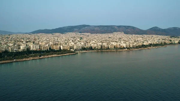 Vista aérea de las casas frente al mar y paisaje urbano de Atenas por la noche, Grecia — Foto de Stock