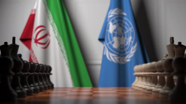 Bandiere dell'Iran e delle Nazioni Unite dietro pedine sulla scacchiera. Animazione concettuale editoriale 3D — Video Stock