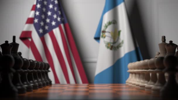 Флаги США и Гватемалы за пешками на шахматной доске. Шахматная игра или политическое соперничество — стоковое видео