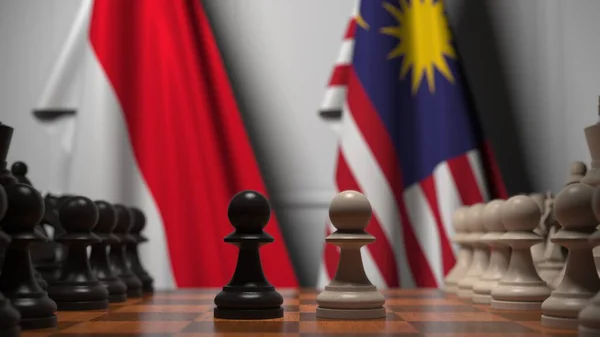 Flaggor i Indonesien och Malaysia bakom brickor på schackbrädet. Schackspel eller politisk rivalitet relaterad till 3D-rendering — Stockfoto