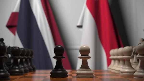 Флаги Таиланда и Сингапура за пешками на шахматной доске. Шахматная игра или политическое соперничество — стоковое фото