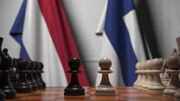 Флаги Нидерландов и Финляндии за пешками на шахматной доске. Шахматная игра или политическое соперничество — стоковое фото