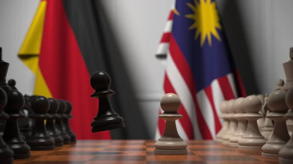 Flaggen von Deutschland und Malaysia hinter Bauern auf dem Schachbrett. Schachspiel oder politische Rivalität im Zusammenhang mit 3D-Darstellung — Stockfoto