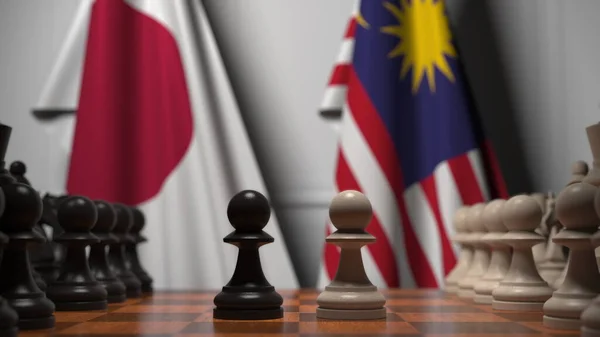 Flaggen Japans und Malaysias hinter Bauern auf dem Schachbrett. Schachspiel oder politische Rivalität im Zusammenhang mit 3D-Darstellung — Stockfoto
