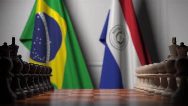 Bandeiras do Brasil e Paraguai atrás de peões no tabuleiro de xadrez. Jogo de xadrez ou rivalidade política relacionada com animação 3D — Vídeo de Stock