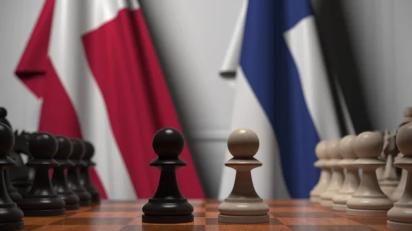 Danmarks och Finlands flaggor bakom spelbrickor på schackbrädet. Schackspel eller politisk rivalitet relaterad till 3D-rendering — Stockfoto