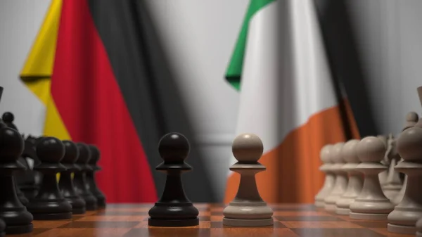 Németország és Írország zászlói gyalogok mögött a sakktáblán. Sakk játék vagy politikai rivalizálás kapcsolódó 3d renderelés — Stock Fotó