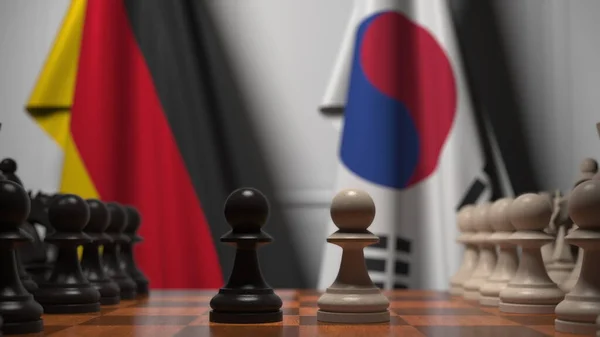 Sakk játék Németország és Korea zászlói ellen. Politikai versennyel kapcsolatos 3d tetemeltakarítás — Stock Fotó