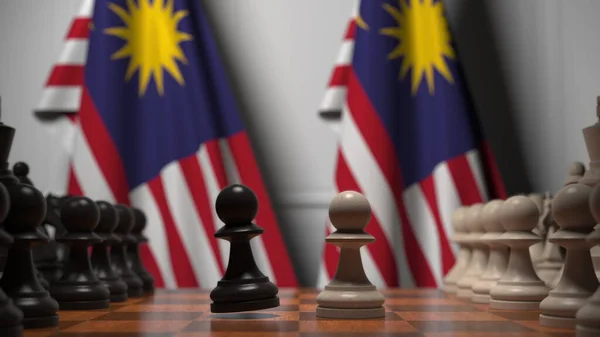 Malaysias flaggor bakom brickor på schackbrädet. Schackspel eller politisk rivalitet relaterad till 3D-rendering — Stockfoto