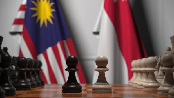 Flags of Malaysia and Singapore behind pawns on the chessboard. Chess game or political rivalry related 3D rendering — Stock Photo, Image