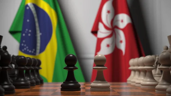 Banderas de Brasil y Hong Kong detrás de peones en el tablero de ajedrez. Juego de ajedrez o rivalidad política relacionada con la representación 3D — Foto de Stock