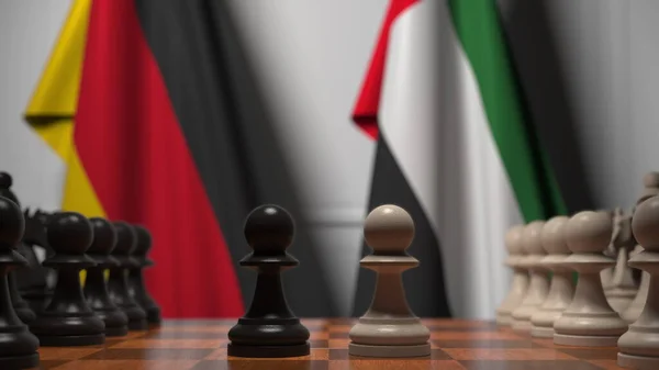 Németország és Uae zászlói gyalogok mögött a sakktáblán. Sakk játék vagy politikai rivalizálás kapcsolódó 3d renderelés — Stock Fotó
