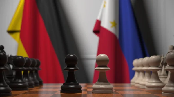 チェスボード上の質屋の後ろにドイツとフィリピンの旗。チェスゲームや政治的ライバル関係の3Dレンダリング — ストック写真