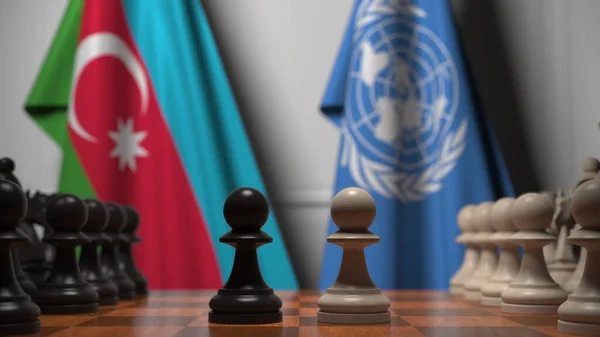 Banderas de Azerbaiyán y las Naciones Unidas detrás de peones en el tablero de ajedrez. Conceptual editorial 3D rendering — Foto de Stock