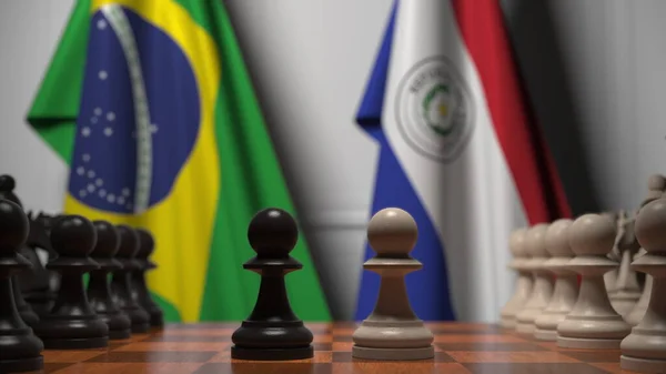 Banderas de Brasil y Paraguay detrás de peones en el tablero de ajedrez. Juego de ajedrez o rivalidad política relacionada con la representación 3D — Foto de Stock