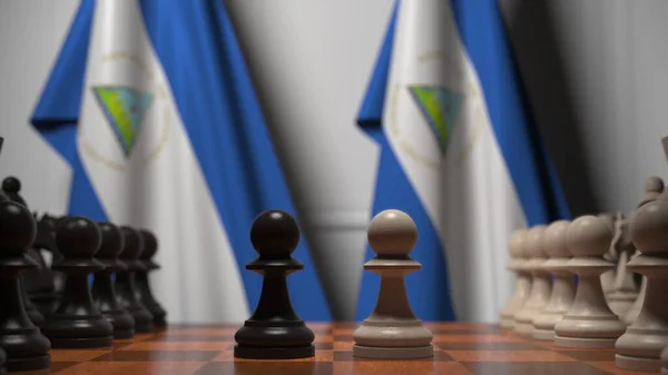 Bandeiras da Nicarágua atrás de peões no tabuleiro de xadrez. Jogo de xadrez ou rivalidade política relacionada com a renderização 3D — Fotografia de Stock
