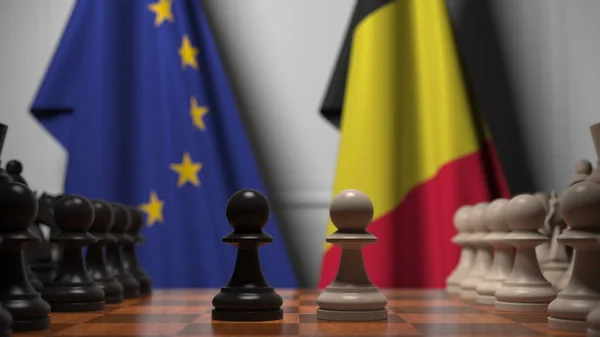 Bandiere dell'UE e del Belgio dietro pedine sulla scacchiera. Rendering 3D relativo alla partita a scacchi o alla rivalità politica — Foto Stock