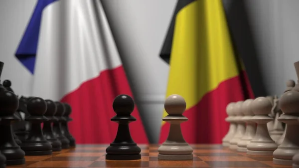 Francia és belga zászlók gyalogok mögött a sakktáblán. Sakk játék vagy politikai rivalizálás kapcsolódó 3d renderelés — Stock Fotó