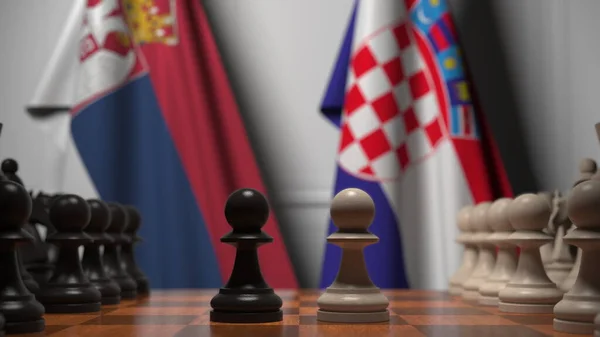 Drapeaux de Serbie et de Croatie derrière des pions sur l'échiquier. Jeu d'échecs ou rivalité politique liée au rendu 3D — Photo