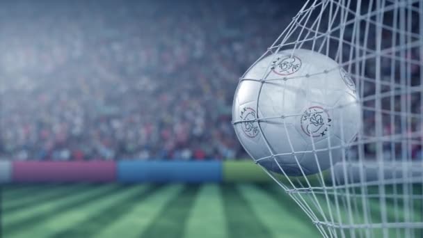 Piłka z logo klubu piłkarskiego Afc Ajax trafia w siatkę bramkową. Konceptualna animacja 3d — Wideo stockowe
