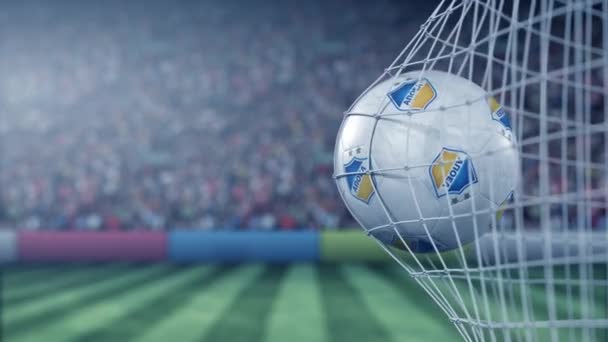 Bola con el logotipo del club de fútbol Apoel FC golpea la red de goles de fútbol. Editorial conceptual Animación 3D — Vídeo de stock