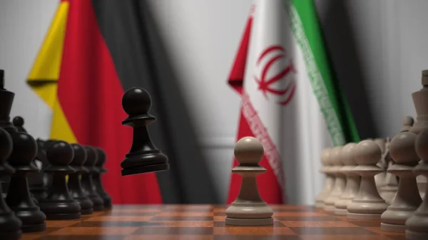 Almanya ve İran 'ın bayrakları satranç tahtasındaki piyonların arkasında. Satranç ya da siyasi çekişme ile ilgili 3 boyutlu yorumlama — Stok fotoğraf