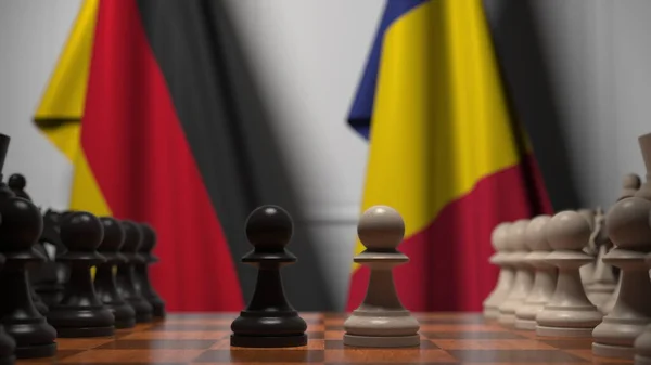 Flaggen von Deutschland und Rumänien hinter Bauern auf dem Schachbrett. Schachspiel oder politische Rivalität im Zusammenhang mit 3D-Darstellung — Stockfoto