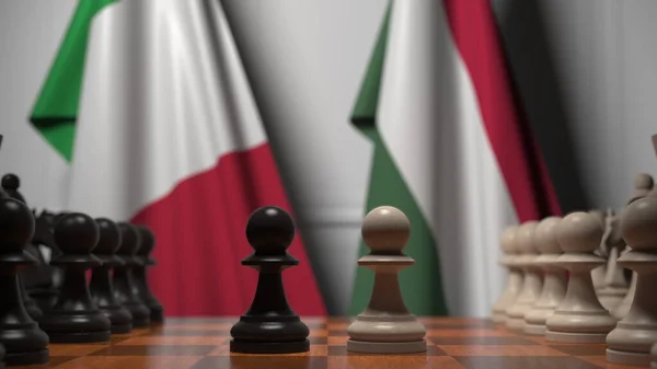 チェスボード上の質屋の後ろにイタリアとハンガリーの旗。チェスゲームや政治的ライバル関係の3Dレンダリング — ストック写真