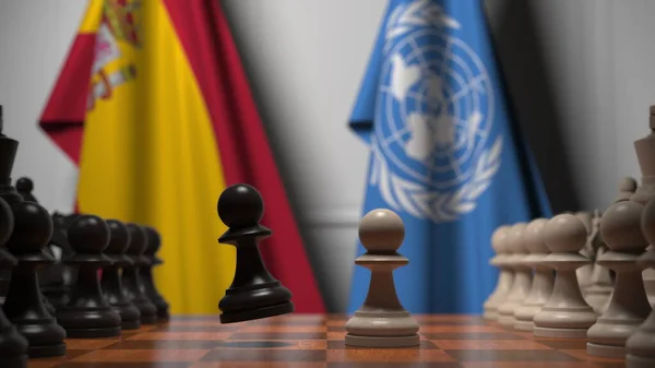 Σημαίες της Ισπανίας και των Ηνωμένων Εθνών πίσω από πιόνια στη σκακιέρα. Σκάκι παιχνίδι ή πολιτική αντιπαλότητα που σχετίζονται 3d απόδοση — Φωτογραφία Αρχείου