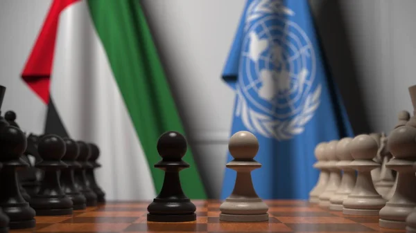 Banderas de los Emiratos Árabes Unidos y las Naciones Unidas detrás de peones en el tablero de ajedrez. Conceptual editorial 3D rendering — Foto de Stock