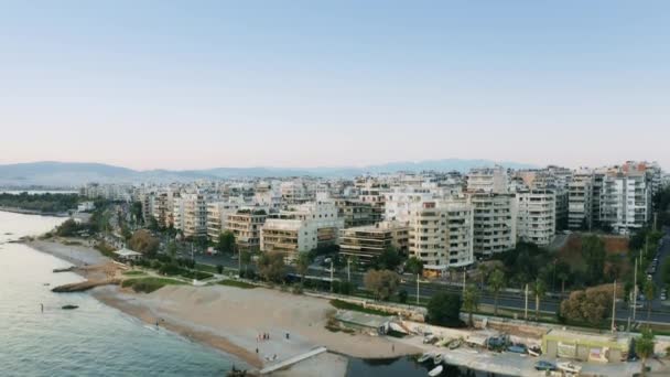 एथेंस, ग्रीस के एक तटीय जिले पलाओ फालिरो के समुद्र तट घरों का हवाई शॉट — स्टॉक वीडियो