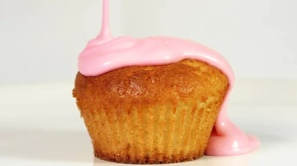 Cubriendo pastel con glaseado rosa, primer plano — Foto de Stock