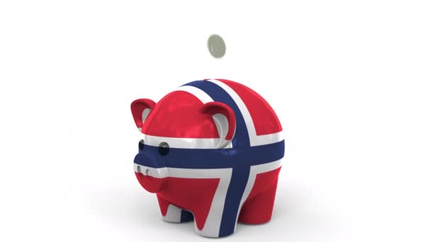 Coins fall into piggy bank painted with flag of Norway. National banking system or savings related conceptual 3D animation — Stock Video
