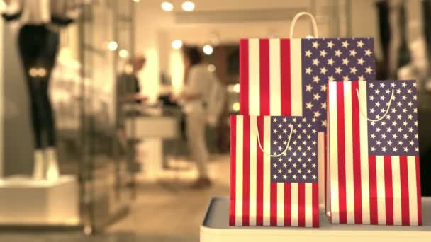 Handler poser med USAs flagg mot en utydelig butikk. Amerikanske shoppingsrelaterte klipp – stockvideo