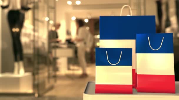 Bolsas de compras con bandera de Francia contra tienda borrosa. Francés compras relacionadas clip — Vídeo de stock